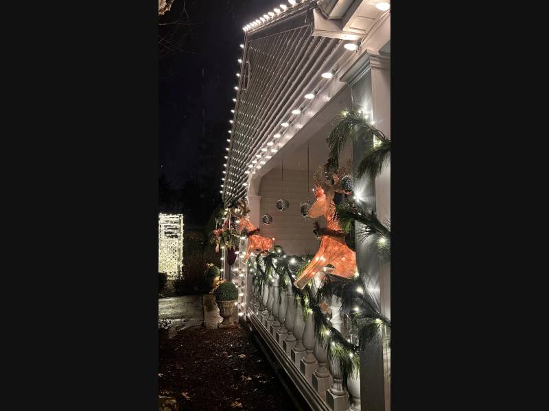 Holiday porch garland with illuminated reindeer decorations