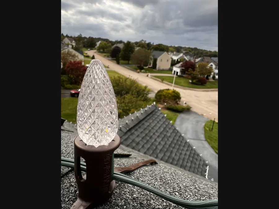 Close-up of a clipped holiday bulb along a roof edge