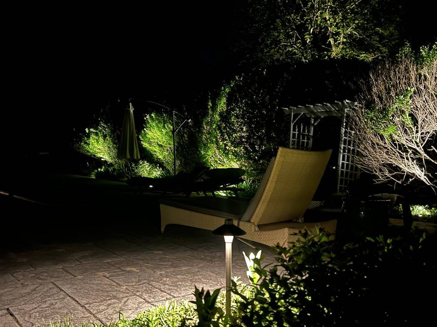 Warm landscape lighting around a residential garden bed