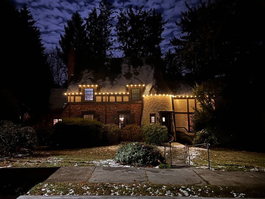 Holiday roofline lighting viewed from a Newton front walk