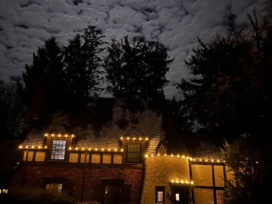 Side entry roofline lighting on a Newton home after snowfall