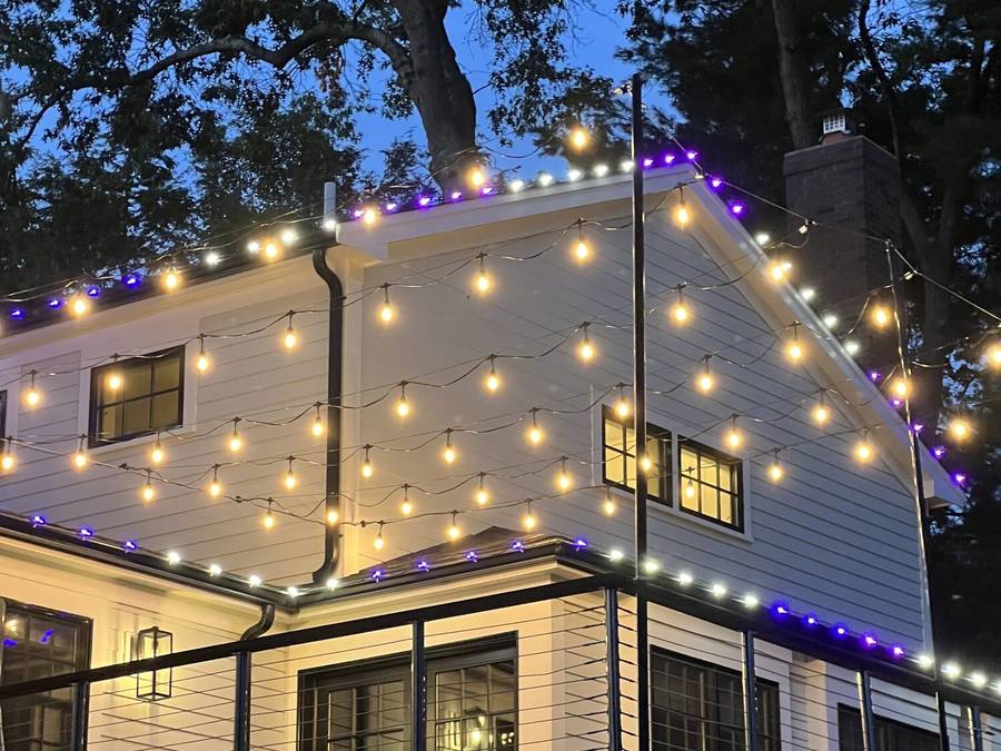 Purple permanent roofline lights paired with warm patio cafe lights