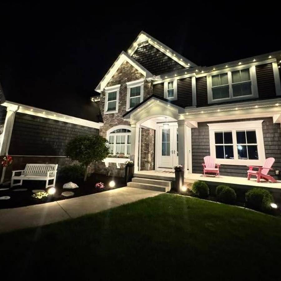 Permanent outdoor lighting on a residential roofline at night