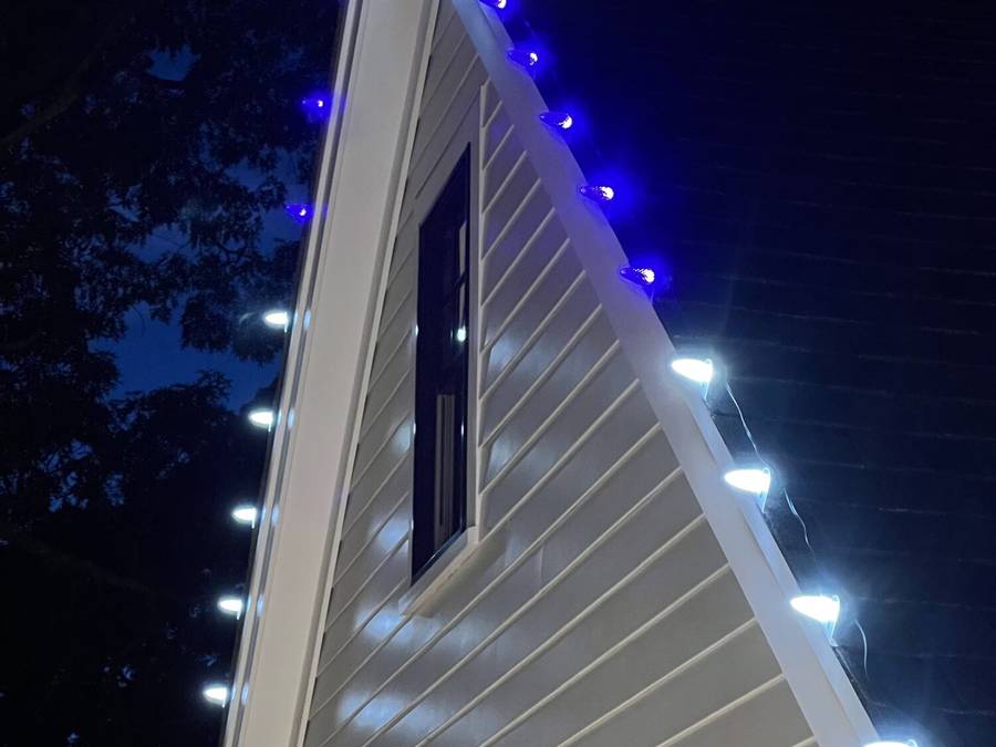Blue and white permanent roofline lights on a local home