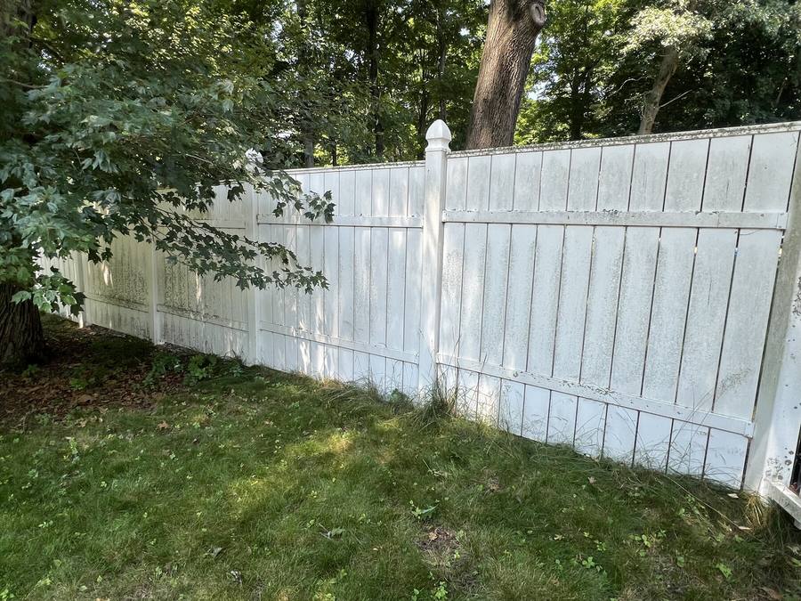 Privacy fence before soft washing with visible staining