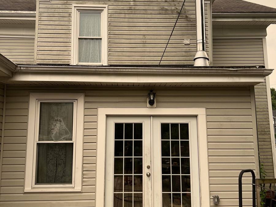 House siding before soft washing with heavy organic staining